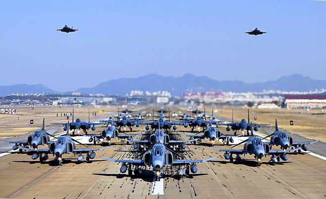 8일 수원기지 활주로에서 F-4E 팬텀기(앞줄부터 8대)를 비롯한 전투기 30여 대가 '엘리펀트 워크' 훈련을 펼치기 위해 도열해 있다. 이는 전투기 수십 대가 밀집 대형을 이뤄 이륙 직전까지 지상 활주를 하는 훈련이다. 이날 훈련은 오는 6월 퇴역할 팬텀기의 명예 은퇴를 축하하는 의미를 더해 실시됐다.   공군