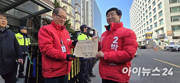 박용호 국민의힘 예비후보(오른쪽)가 9일 서울특별시 여의도 국민의힘 중앙당사 앞에서 기자회견을 마친 뒤 당 관계자에게 한동훈 비대위원장 앞으로 보내는 '제경선 및 무공천'을 촉구하는 호소문을 전달하고 있다. [사진=독자 제공]