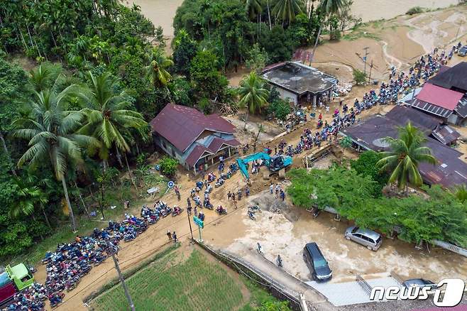 폭우로 인한 홍수와 산사태가 인도네시아 서부 수마트라주를 강타한 가운데 9일(현지시간) 서부 수마트라주에 위치한 페시르 셀라탄 리젠시에서 운전자들이 진흙길을 운전하는 모습. 24.03.09 ⓒ AFP=뉴스1 ⓒ News1 김예슬 기자