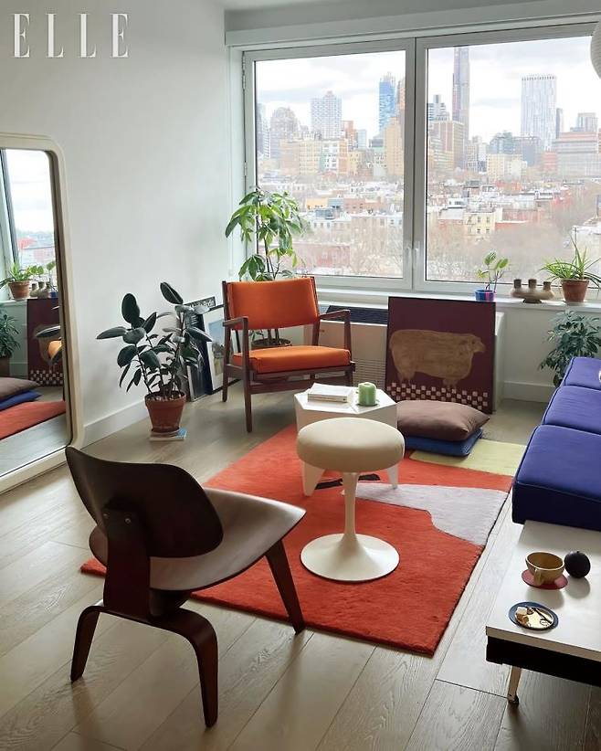 브루클린의 전경이 한눈에 보이는 집. 쨍한 보라색의 70년대 조지 넬슨 모듈러 소파와 이사무 노구치의 화이트 프리즈메틱 테이블로 포인트를 주었다.