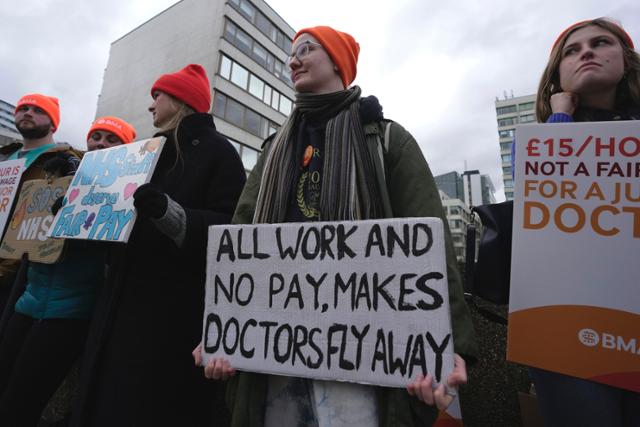 지난달 26일(현지시간) 영국의학협회(BMA) 회원인 수련의들이 영국 런던의 세인트토머스 병원 밖에서 피켓을 들고 시위를 하고 있다. 런던 AP=연합뉴스