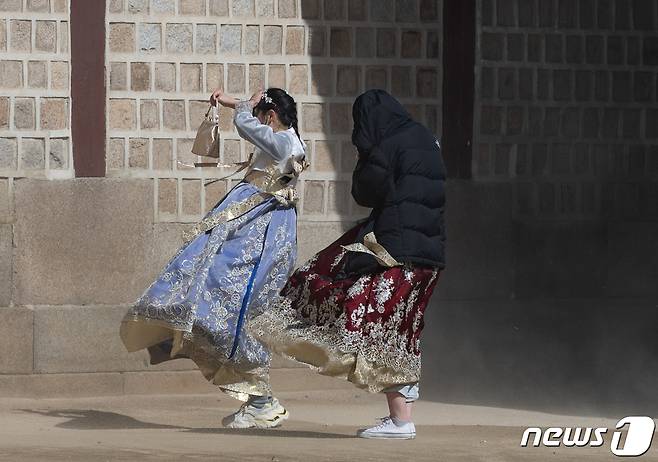 서울 종로구 경복궁을 찾은 외국인 관광객들이 바람에 날리는 모래를 피하고 있다. ⓒ News1 이재명 기자