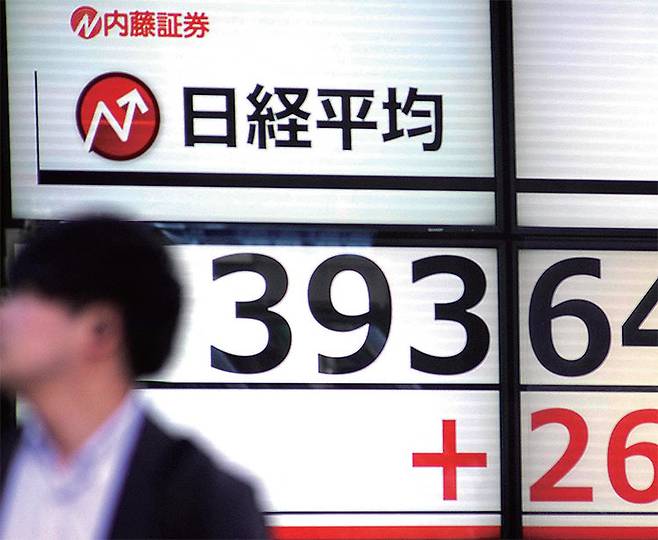 일본 도쿄 시내에 설치된 증시 현황판 앞을 한 남성이 지나가고 있다. 사진연합뉴스