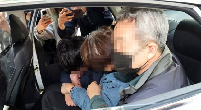 수원 전세사기 의혹 일가가 고개를 푹 숙여 얼굴을 가리고 있다. / 사진=연합뉴스