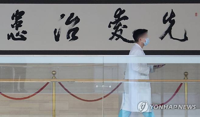 '먼저 사랑의 마음을 가지고 환자를 치료한다' (서울=연합뉴스) 김성민 기자 = 정부의 의대 정원 증원 정책에 반발한 전공의들이 집단 행동을 이어가고 있는 25일 오전 서울 시내 한 대형병원에서 한 의료인이 '선애치환(先愛治患)'이라고 적힌 붓글씨 작품 앞을 지나고 있다. 선애치환은 '먼저 사랑의 마음을 가지고 환자를 치료한다'는 뜻을 담고 있다. 2024.2.25 ksm7976@yna.co.kr