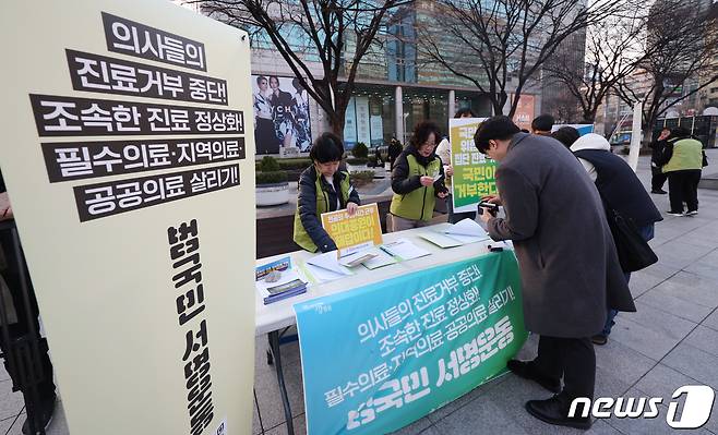 전국보건의료산업노조 관계자들이 13일 오후 서울 종로구 동화면세점 앞에서 의사들의 진료 정상화를 촉구하는 필수의료·지역의료·공공의료 살리기 범국민 서명운동을 하고 있다. 2024.3.13/뉴스1 ⓒ News1 김민지 기자