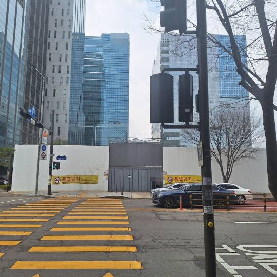 12일 오후 서울 상암초등학교 인근의 한 공사장 앞 흡연금지 현수막이 걸린 곳에서 사람들이 담배를 태우고 있다.<박상길 기자>