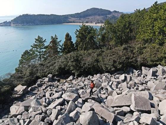 생일도 둘레길의 ‘멍터’에 암괴류가 있다. 암괴류는 돌이 흐르는 것 같은 ‘돌강’을 말한다. 사진 가운데 짙은 나무들이 동백이고, 뒤로 금곡해수욕장이 보인다.