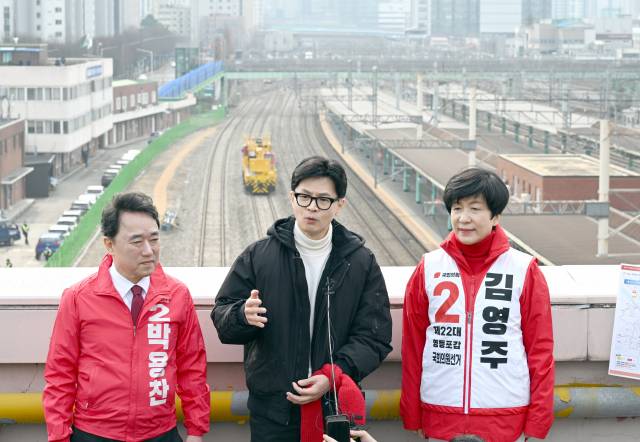 한동훈(가운데) 국민의힘 비상대책위원장이 12일 서울 영등포역 옥상에서 김영주(영등포갑)·박용찬(영등포을) 후보와 함께 '철도 지하화' 공약을 설명하고 있다. 오승현 기자 2024.03.12