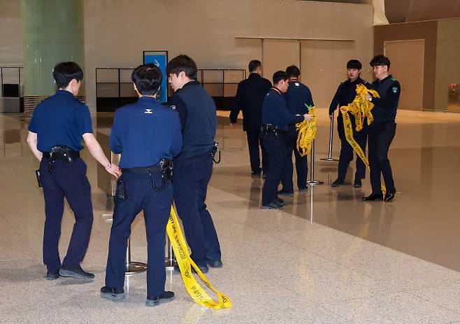 지난 10일 오후 인천국제공항 제2터미널에서 해병대 수사 외압 의혹을 받고 있는 이종섭 주호주대사의 호주행 비행편 탑승이 확인되자 경찰들이 안전을 위해 설치한 폴리스라인을 치우고 있다. (사진=뉴시스)