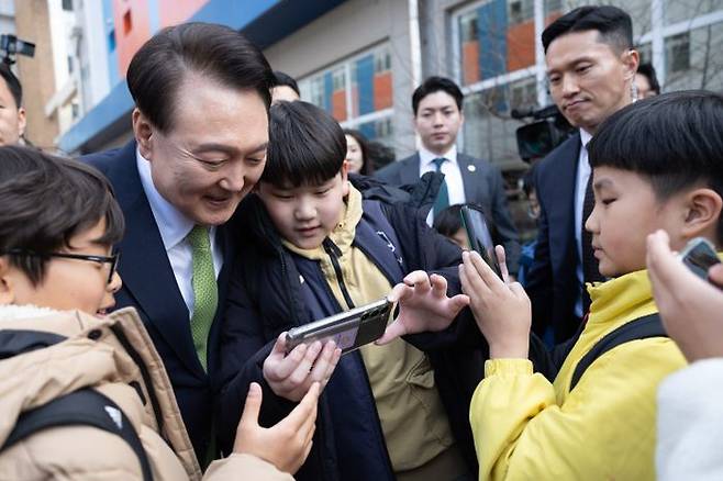윤석열 대통령이 14일 전남 무안군 오룡초등학교 도서관에서 늘봄학교 간담회를 마친 뒤 학교를 떠나며 학생들과 기념사진을 찍고 있다.ⓒ연합뉴스