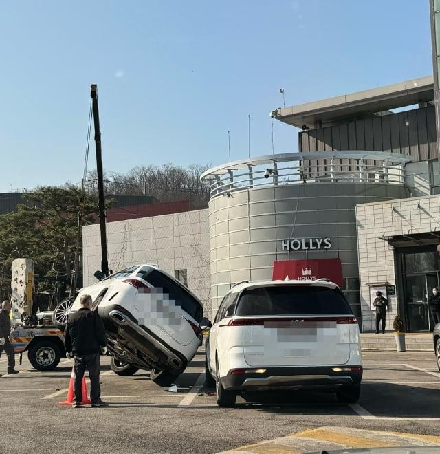 지난 13일 서울 만남의광장 휴게소에서 크레인으로 벤츠 차량을 끌어내고 있다. 온라인 커뮤니티 캡처