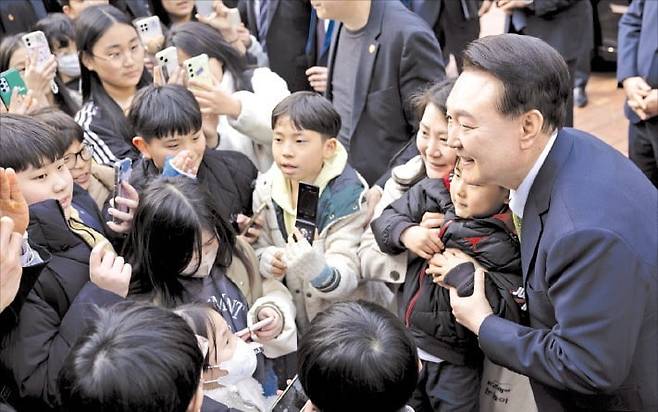 < 늘봄학교 간 尹대통령 > 윤석열 대통령이 14일 전남 무안군 오룡초등학교 도서관에서 ‘늘봄학교’ 간담회를 마친 뒤 학교를 떠나며 학생들과 기념사진을 찍고 있다.  /대통령실 제공