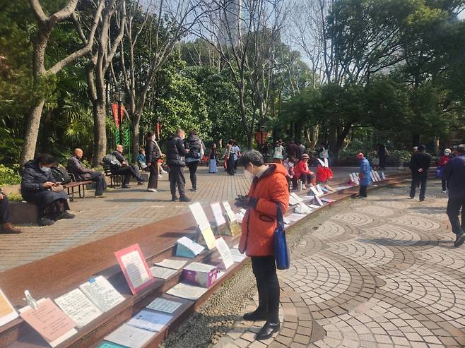 지난 2일 오전 상하이 인민공원에서 자녀의 결혼 상대를 찾는 부모들이 남녀의 프로필을 살펴보고 있다. /사진=박수현 기자