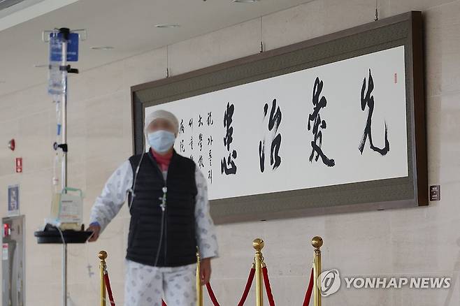 '먼저 사랑의 마음을 가지고 환자를 치료한다' (서울=연합뉴스) 김성민 기자 = 25일 오전 서울 시내 한 대형병원에서 한 환자가 '선애치환(先愛治患)'이라고 적힌 붓글씨 작품을 지나치고 있다. 선애치환은 '먼저 사랑의 마음을 가지고 환자를 치료한다'는 뜻을 담고 있다. 2024.2.25 ksm7976@yna.co.kr
