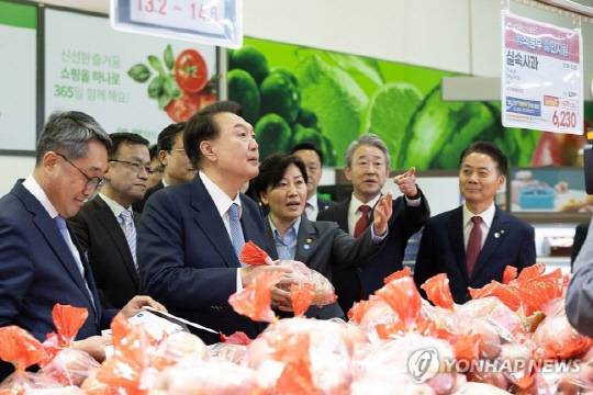 윤석열 대통령이 18일 서울 서초구 농협 하나로마트 양재점 과일 매장에서 농림축산식품부 할인 지원 사과를 살피며 과일 물가를 점검하고 있다. 사진 연합뉴스