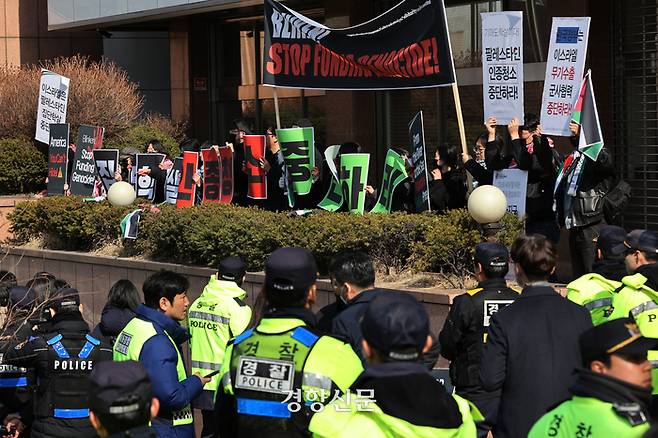 167개 시민·사회 단체로 구성된 ‘팔레스타인과 연대하는 한국 시민사회 긴급행동’ 활동가들이 18일 제3차 민주주의 정상회의 개회식이 열리는 서울 중구 신라호텔 인근 동대입구역에서 미국의 이스라엘 지원 중단을 촉구하며 손팻말을 들고 있다. 조태형 기자