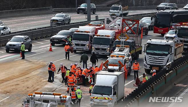 [성남=뉴시스] 김근수 기자 = 19일 경기 성남시 경부고속도로 판교IC 인근 서울 방면 도로에서 한국도로공사 직원들이 도로에 쏟아진 잔해물을 정리하고 있다. 소방과 경찰에 따르면 이날 오전 6시쯤 경기 성남시 인근 경부고속도로 판교IC 양재방면 도로에서 A(60대)씨가 몰던 25톤 트레일러와 B(50대)씨가 운전하던 25톤 덤프트럭이 충돌했다. 2024.03.19. ks@newsis.com