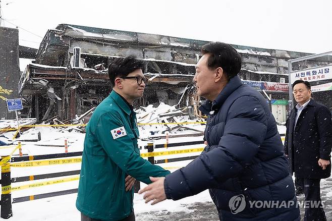 서천시장 화재현장에서 만난 윤석열 대통령과 한동훈 비대위원장 (서울=연합뉴스) 진성철 기자 = 윤석열 대통령이 23일 충남 서천군 서천읍 서천특화시장 화재 현장에서 국민의힘 한동훈 비상대책위원장과 만나 악수하고 있다. 2024.1.23   [대통령실 제공. 재판매 및 DB 금지] zjin@yna.co.kr