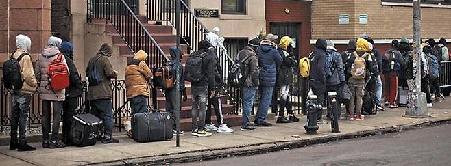 늘어나는 재정 부담에 미국 뉴욕시와 시카고시가 이민자들에게 적용하는 ‘쉼터 권리’를 수정, 무료 숙소 제공 혜택을 축소했다. 사진은 지난해 12월 5일 뉴욕 성 브리짓 초등학교의 이민자 지원센터 밖에 줄 선 이민자들. /AP 연합뉴스
