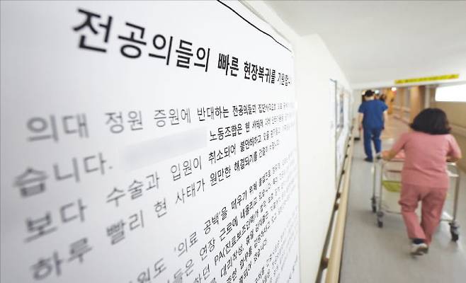 < “전공의 돌아와달라” 대형 벽보 > 전공의 집단행동이 한 달째 이어지는 가운데 19일 서울의 한 대형병원에 ‘전공의들의 빠른 현장 복귀를 기원한다’는 내용의 대형 벽보가 붙어 있다.  연합뉴스