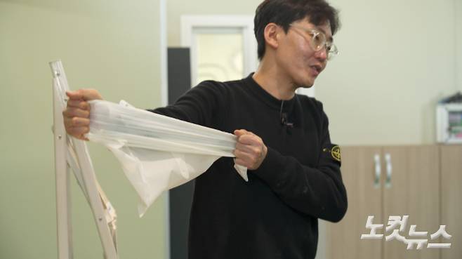 라이스팜 박재민 대표가 쌀로 만든 플라스틱 대체재료로 찍어낸 비닐 봉지를 당겨보고 있다. 일반 플라스틱 비닐보다 인장력이 강하다. 권혁주 기자