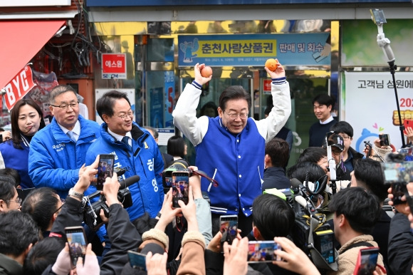 사과·한라봉 들고 “고물가에 서민 고통” - 이재명(오른쪽) 더불어민주당 대표가 19일 강원 춘천시 명동거리를 방문해 시민들에게 받은 사과와 한라봉을 두 손에 들고 “터무니없는 물가에 우리 서민들이 너무 고통받고 있다”며 과일값 상승을 매개로 한 정권심판론을 강조하고 있다. 이 대표 왼쪽은 허영(춘천·철원·화천·양구갑) 민주당 의원. 춘천 뉴스1