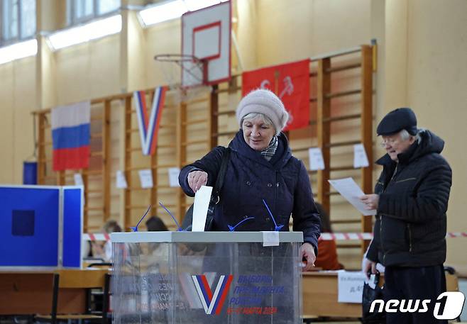 사흘간 치러지는 러시아 대선의 마지막 날인 17일(현지시간) 상트페테르부르크에서 투표를 마친 여성 유권자가 투표 용지를 투표함에 넣고 있다. 사진 속 인물은 기사 내용과는 무관함. 2024.3.17. ⓒ 로이터=뉴스1 ⓒ News1 김성식 기자