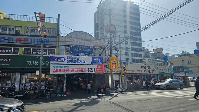 국민의힘과 더불어민주당 플랜카드가 같이 걸려 있는 용호 골목시장의 모습. /박지영 기자