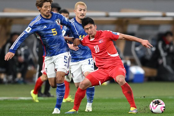 북한 축구대표팀의 한광성(오른쪽)이 21일 일본과의 월드컵 2차 예선 3차전에서 일본 수비수를 뚫고 있다. AFP=연합뉴스