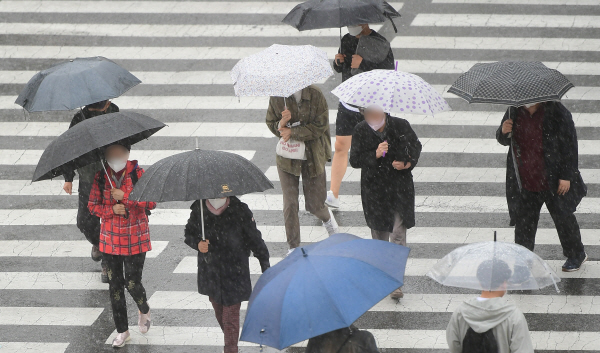 봄비가 내리는 가운데 우산을 쓰고 이동 중인 부산 시민의 모습. 국제신문DB