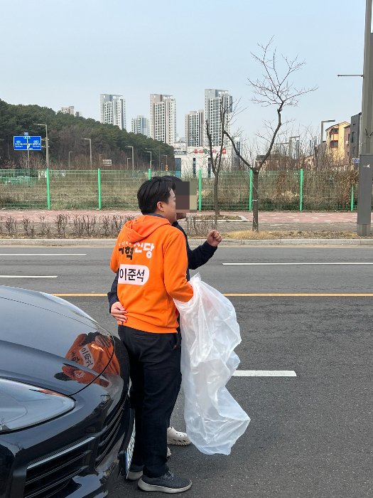 이준석 개혁신당 대표가 19일 출근인사 후 이동하다 한 주민 요청에 사진 촬영을 하고 있다. /사진=박소연 기자