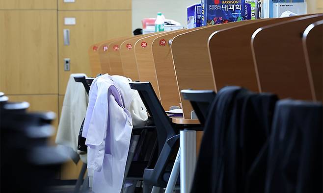 지난 20일 한 의과대학 열람실에 의사 실습 가운과 의학 서적이 보이고 있다. 연합뉴스