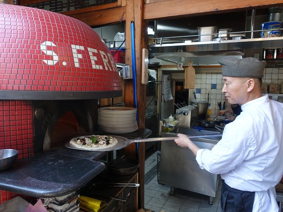 이탈리아에서 제작해 온 화덕에 구울 피자를 넣는 이재성 피자이올로. [사진 이택희]