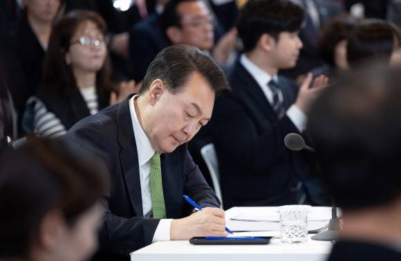 윤석열 대통령이 지난 21일 강원도 원주 건강보험심사평가원에서 ‘건강하고 행복한 노후’ 주제로 열린 스물두 번째 국민과 함께하는 민생토론회에서 메모를 하고 있다. 대통령실 제공