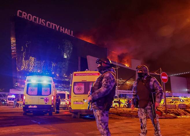 지난 22일 밤(현지시간) 총격 테러와 화재가 발생한 러시아 모스크바 크로커스 시티홀 콘서트장에서 소총으로 중무장한 당국 요원이 주차장 일대를 수색하고 있다.  로이터연합뉴스