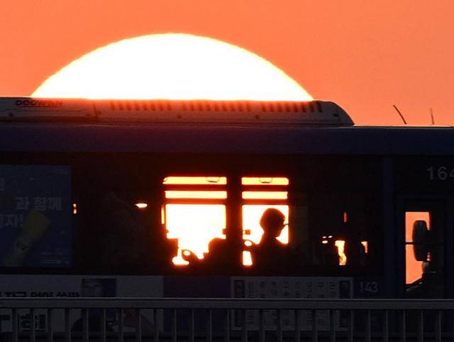 한강에 노을이 붉게 물든 저녁 무렵 반포대교 위를 지나는 버스 안으로 저물어가는 태양 빛이 스며들면서 삶에 지친 사람들에게 따스한 위로를 건네고 있다.