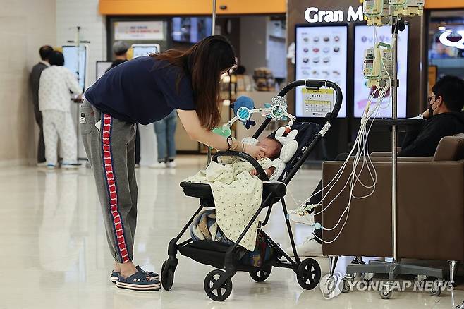 아이에게는 너무 무거운 짐 (서울=연합뉴스) 임화영 기자 = 정부의 의대 정원에 반발한 전국 의대 교수들의 사직서 제출과 전공의 면허정지 처분을 하루 앞둔 24일 서울 시내의 한 대학병원에서 한 소아환자의 보호자가 아이를 돌보고 있다.
    전국 의대 교수 비상대책위원회는 25일부터 19개 대학별로 사직서를 제출하기로 결의했으며, 보건복지부는 업무개시명령에도 돌아오지 않은 전공의들의 면허를 내일부터 차례로 정지시킬 계획이다. 2024.3.24 hwayoung7@yna.co.kr