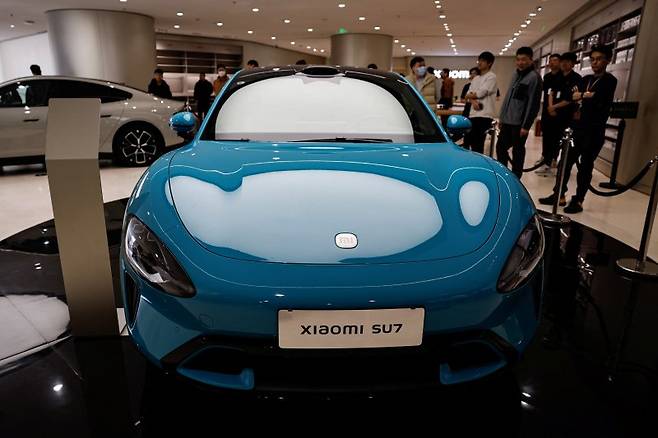 베이징의 한 전시장에 전시된 샤오미의 첫 전기자동차 SU7. 28일 공식 출시 행사를 앞두고 25일부터 베이징, 상하이 등 중국 전역 29개 도시 59개 매장에서 일단 외형만 선보이고 있다. 로이터 뉴스1
