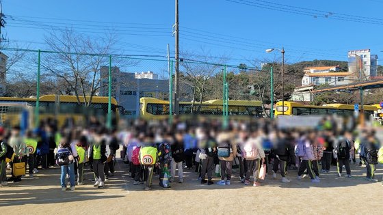 지난 21일 경남 통영시 광도면 제석초등학교 운동장. 화재로 교실을 잃은 학생들이 다른 학교로 '원정 수업'을 떠나기 위해 통학버스를 기다리고 있다. 18일 화재가 발생한 제석초는 복구 작업에 1년 가까이 걸릴 전망이다. 사진 경남교육청