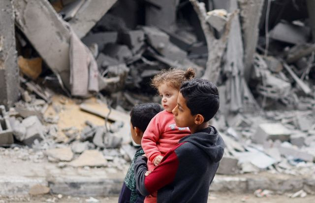 팔레스타인 가자지구 아이들이 지난 24일(현지시간) 남부 라파에서 이스라엘군의 공습으로 파괴된 거리를 보고 있다. 로이터연합뉴스