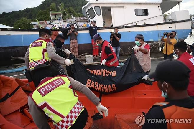 24일(현지시간) 인도네시아 아체주 구조대원과 경찰이 로힝야 난민으로 추정되는 시신을 옮기고 있다.  [AP 연합뉴스 자료사진. 재판매 및 DB 금지]