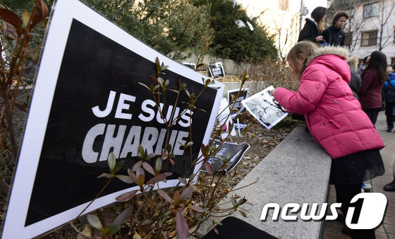 11일 오후 서울 서초구 반포4동 은행나무공원에서 열린 프랑스 파리 언론인 테러 추모행사에서 참가자들이 '내가 샤를리다(Je suis Charlie)'라는 팻말을 공원 모퉁이에 올려놓고 있다. 이날 이들은 희생자를 애도하며 어떠한 경우에도 표현의 자유는 억압 받아서는 안된다고 말했다. 2015.1.11/뉴스1 ⓒ News1 박지혜 기자