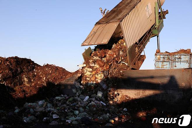 미국 캘리포니아주(州) 버날리스 인근의 음식물 쓰레기 처리장에서 대형 트럭이 컨테이너에 가득 담긴 쓰레기를 쏟아내고 있다. 2022.11.10/ ⓒ 로이터=뉴스1 ⓒ News1 권진영 기자