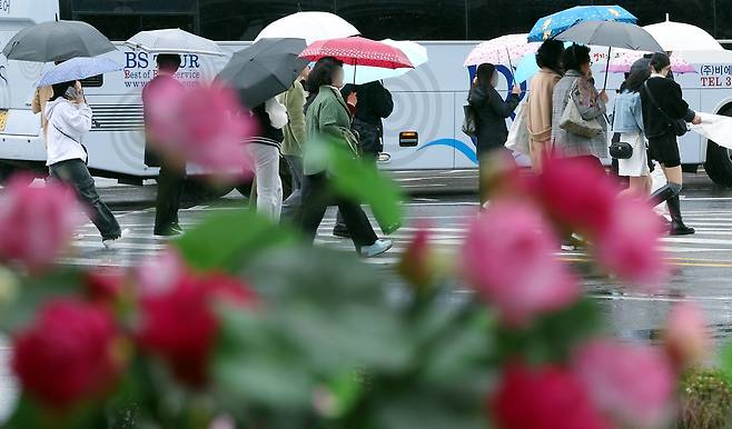 봄비가 내린 25일 오후 서울 종로구 일대를 지나는 우산을 받쳐든 시민들이 발걸음을 재촉하고 있다./뉴스1