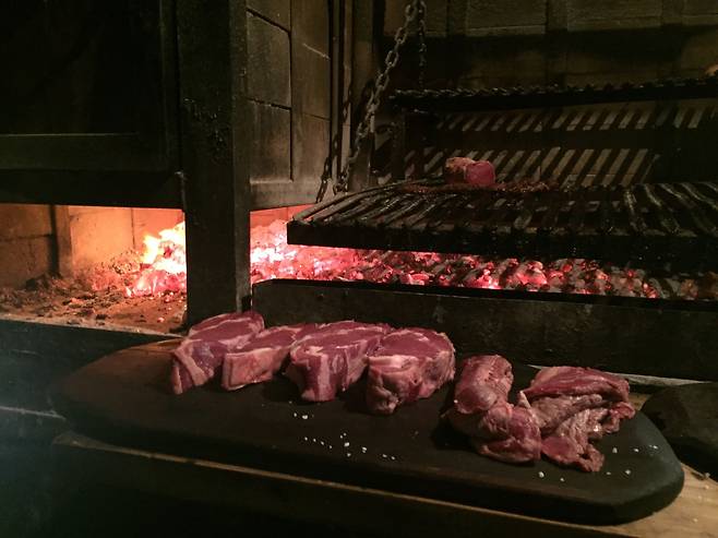 아사도의 시작은 장작용 나무를 태워서 숯을 만드는 작업이다. 그 숯 위에 고기를 얹으면 마법이 시작된다. 오랜 시간, 천천히 익힌다. 강한 불에 빠르게 굽는 우리의 직화구이와는 다른 방식이다.