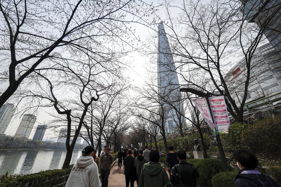 27일 서울 송파구 석촌호수를 찾은 시민들이 벚나무 아래에서 걷고 있다. 송파구는 27일부터 오는 31일까지 석촌호수 일대에서 호수벚꽃축제를 개최한다. 뉴시스