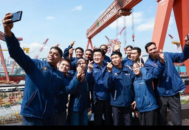 권오갑 HD현대 회장(앞줄 가운데)이 27일 울산 HD현대중공업에서 조선소 협력사 외국인 노동자들과 기념 촬영을 하고 있다. HD현대 제공