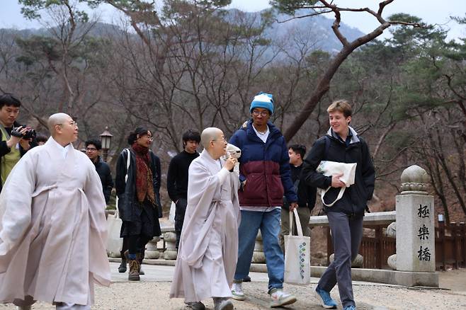 한국으로 교육여행을 온 미 하버드대 학생들이 서울 진관사에서 스님의 설명을 들으며 경내를 걷고 있다.