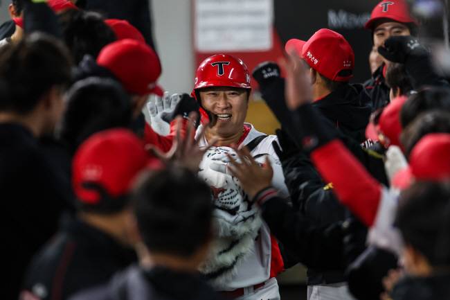 KIA의 최형우가 26일 광주KIA챔피언스필드에서 열린 롯데와의 KBO리그 홈경기에서 6회 말 홈런을 친 뒤 더그아웃에서 백호 가방을 메고 동료들의 축하를 받고 있다. KIA 제공